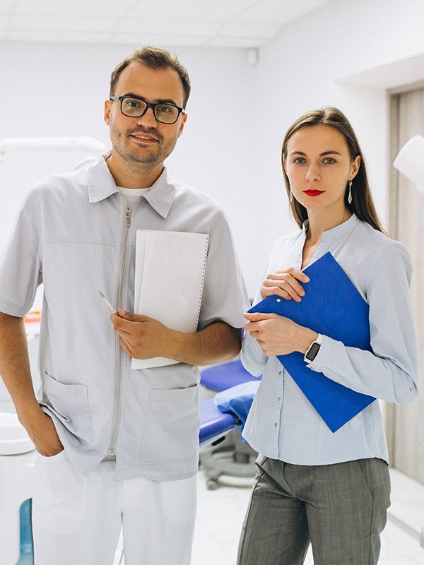 Dentist and patient standing in dental office