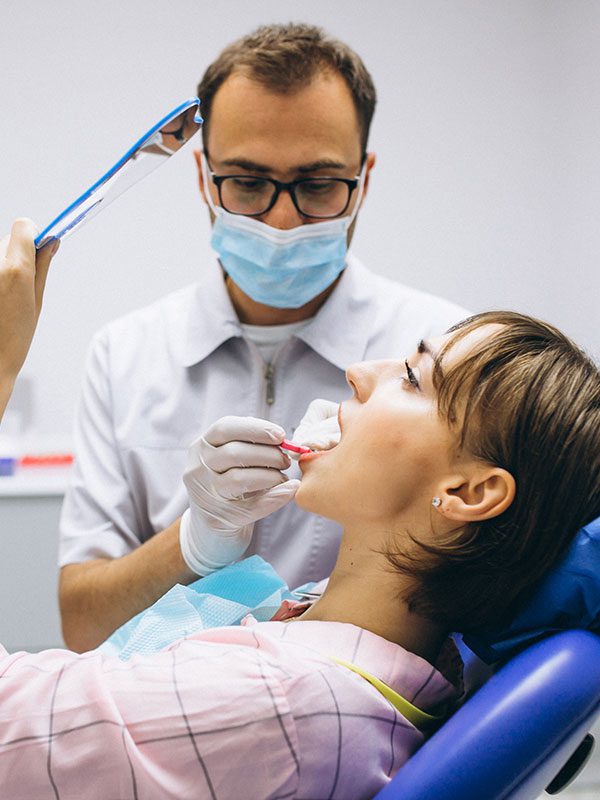 dentist with woman patient in dental chair