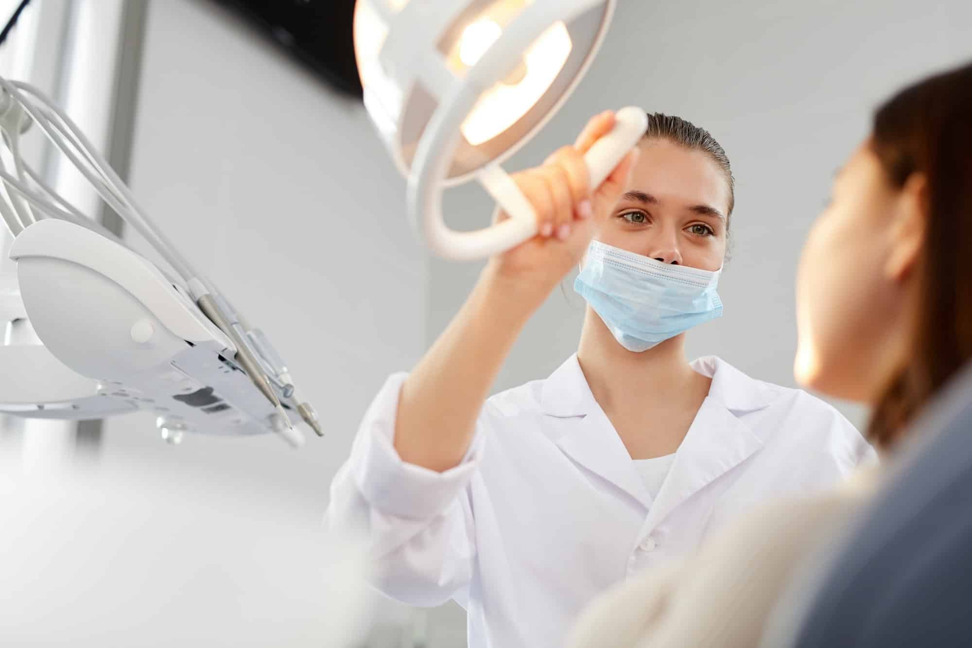 female-dentist-adjusting-lamp